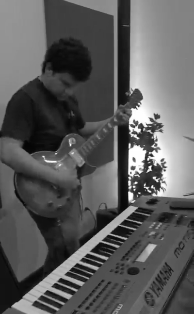 Enzo tocando guitarra en ensayo
